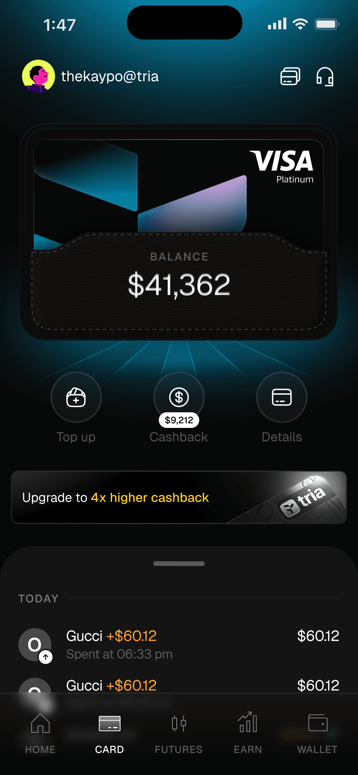 Triaアプリのカード画面。Top up・Cashback・Detailsのボタンと、上位ランクへのアップグレード案内
